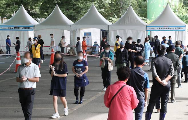 지난 30일 오전 서울 송파구 가락시장 ‘서울시 찾아가는 선별진료소’에서 검사를 받으려는 시민들이 줄을 서 있다. 연합뉴스