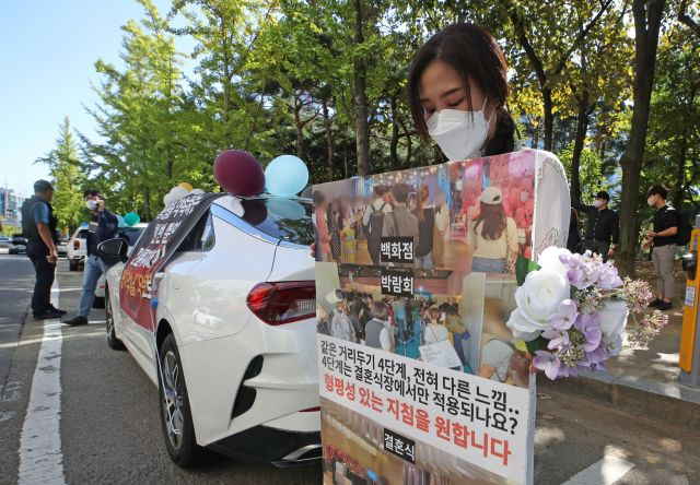 15일 오전 서울 여의도공원 공영주차장에서 전국신혼부부연합회 회원들이 정부의 결혼식 방역 지침 개선을 요구하며 웨딩카 주차시위를 하고 있다. 연합뉴스