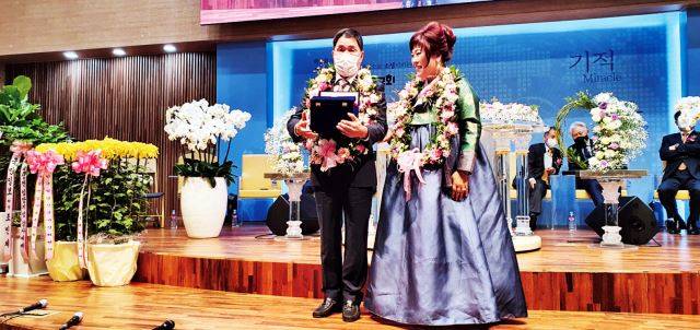 이 장로가 지난 26일 백송교회 새성전 입당 기념 감사예배에서 공로패를 받는 모습. 우측은 이순희 목사.