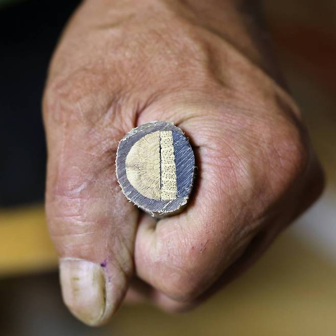 A cross section of a Korean bow shows water buffalo horn (right) bamboo and oak wood wrapped with several layers of cattle tendon, glued with boiled air bladder from a croaker fish. © 2021 Hyungwon Kang