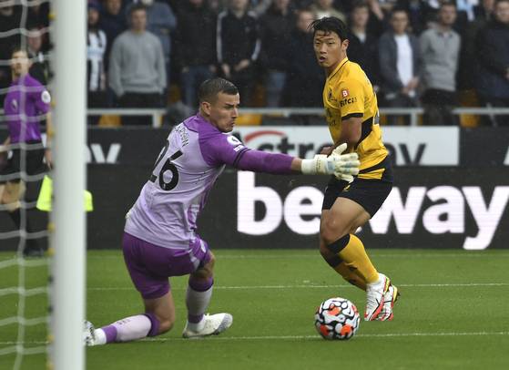 Wolverhampton Wanderers' Hwang Hee-chan, right, beats Newcastle's goalkeeper Karl Darlow to score the opening goal for Wolverhampton Wanderers against Newcastle United at Molineux stadium in Wolverhampton, England on Saturday. [AP/YONHAP]