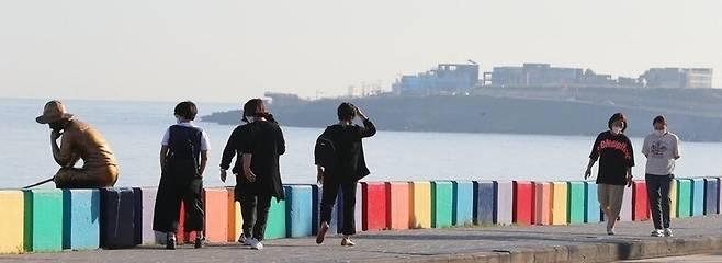 지난 3일 오전 제주시 도두동 해안도로에서 관광객들이 산책하고 있다. 연합뉴스