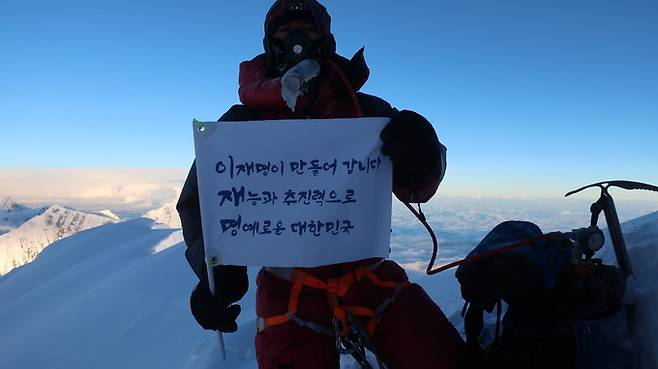 충북 히말라야 14좌 원정대 조철희 등반대장이 우리 시간으로 지난 1일 히말라야 다울라기리 정상에서 더불어민주당 이재명 대선 경선 후보의 이름으로 삼행시가 적힌 깃발을 들고 기념촬영을 하고 있다. 이재명 캠프 제공