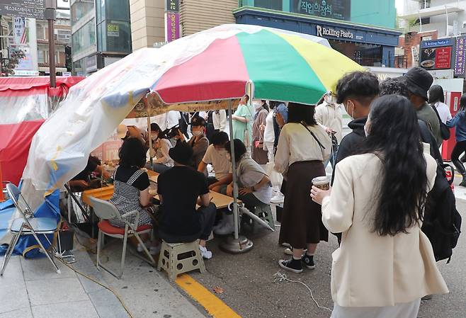 지난 4일 오후 서울 혜화동 대학로의 한 달고나 가게를 찾은 손님들이 줄을 서서 차례를 기다리고 있다. 이 달고나 가게 주인은 '오징어 게임' 촬영 현장으로 가서 직접 달고나를 만들었다. / 오종찬 기자