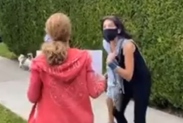 마스크 착용은 아동학대와 같다고 주장하는 안티백서(왼쪽 붉은 옷)에 항의하는 미국 베벌리힐스의 한 초등학생 학부모(오른쪽)