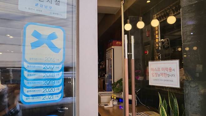 Award-winning restaurant stickers given by Blue Ribbon Survey are posted at the entrance of Cheongdamgol. (Kim Hae-yeon/ The Korea Herald)