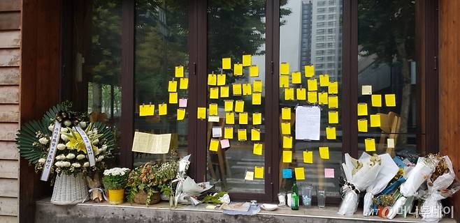 코로나19로 인한 경영난으로 극단적 선택을 한 자영업자가 마포구에서 운영하던 매장 앞에 고인을 추모하는 메모와 국화가 놓여 있다./사진= 박미주 기자