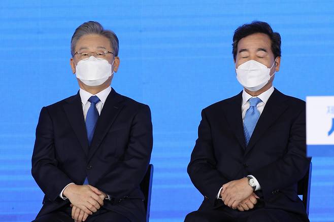 더불어민주당 제20대 대통령 후보에 선출된 이재명 경기지사가 10일 오후 서울 송파구 올림픽공원 SK올림픽핸드볼경기장에서 열린 서울 합동연설회에서 이낙연 경선 후보와 함께 경선 결과를 듣고 있다. [연합]