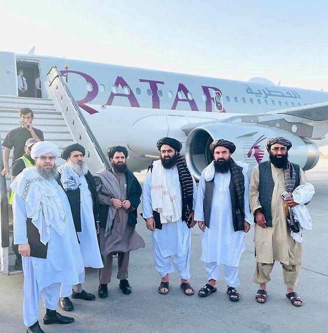 미국과의 협상에 참여한 아프가니스탄 탈레반 정부 대표단이 8일 카타르행 항공기 앞에 모여 있다. 로이터/연합뉴스