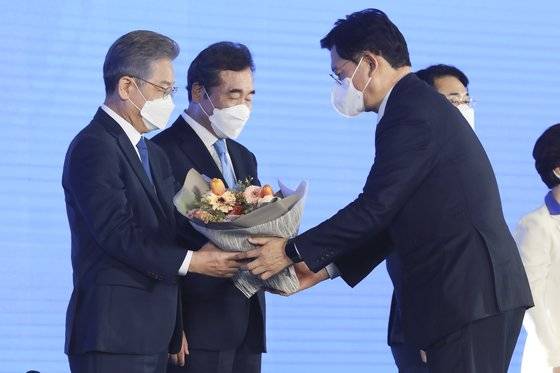 더불어민주당 제20대 대통령 후보에 선출된 이재명 경기도지사가 10일 오후 서울 송파구 올림픽공원 SK올림픽핸드볼경기장에서 열린 서울 합동연설회에서 송영길 대표에게 꽃다발을 받고 있다. 국회사진기자단