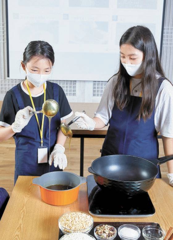 주혜리(왼쪽)·임선민 학생기자가 강봉석 명인이 만든 조청을 살펴보고 있다.