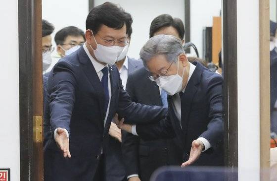 이재명 더불어민주당 대통령 후보(오른쪽)와 송영길 민주당 대표가 11일 '당지도부-대통령 후보 상견례'에 참석하기 위해 회의실에 입장하면서 서로 먼저 들어가라고 양보하고 있다. 뉴스1