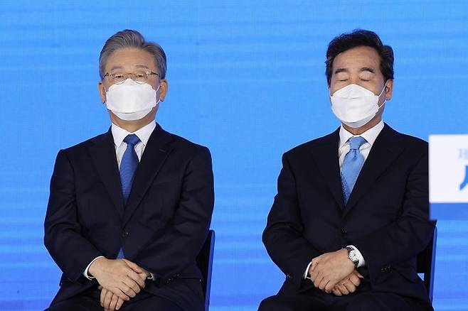 지난 10일, 서울 송파구 올림픽공원 SK올림픽핸드볼경기장에서 열린 서울 합동연설회에서 이재명 더불어민주당 대선 경선 후보(사진 왼쪽)와 이낙연 후보가 결과를 듣고 있다. 연합뉴스