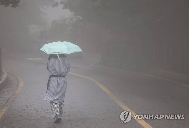 안개 속 산책 가을로 향하는 비가 촉촉이 내린 10월 6일 오후 서울 남산 전망대 인근 산책로에서 우산을 쓴 시민이 안개 속을 걷고 있다. [연합뉴스 자료사진]