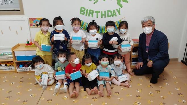 김정식(오른쪽) 사곡면장이 얼굴없는 천사가 기부한 어린이용 마스크를 전달하며 아이들과 함께 기념촬영하고 있다.