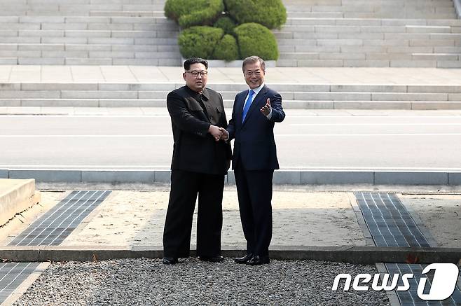 문재인 대통령과 김정은 북한 국무위원장이 27일 오전 남북정상회담이 열리는 판문점 군사분계선 앞에서 만나 악수하고 있다.  2018.4.27/뉴스1 © News1 한국공동사진기자단