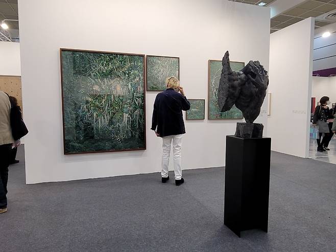 A visitor takes a look at artworks at the Arario Gallery booth. (Park Yuna/The Korea Herald)