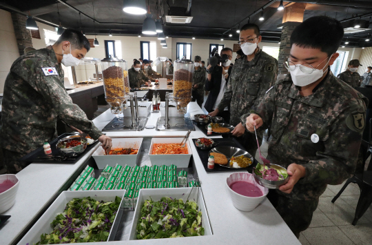 시범 운용 중인 식단 : 13일 장병 급식 개선을 위해 시범운용 중인 육군 32사단 내 ‘더 좋은 병영식당’에서 장병들이 카레와 등심 돈가스, 쫄면 무침, 시리얼, 우유, 요구르트 등으로 구성된 점심 메뉴를 식판에 담고 있다. 뉴시스