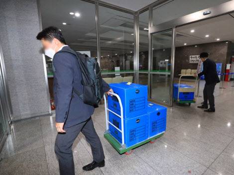 대장동 개발 로비·특혜 의혹 사건을 수사 중인 검찰이 15일 오후 경기도 성남시청 압수수색을 마친 후 압수품을 옮기고 있다.(사진=연합뉴스)