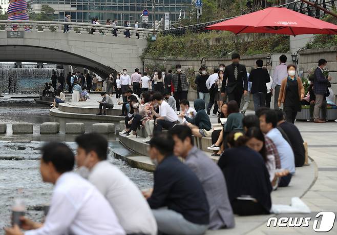 14일 오후 서울 중구 청계천에서 직장인들이 점심시간을 이용해 휴식을 취하고 있다.  © News1 신웅수 기자