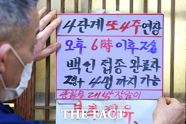 9월6일 오후 서울 종로구 광화문의 한 음식점에서 관계자가 거리두기 연장과 백신 인센티브 관련 문구가 적힌 안내문을 붙이고 있다. /남용희 기자