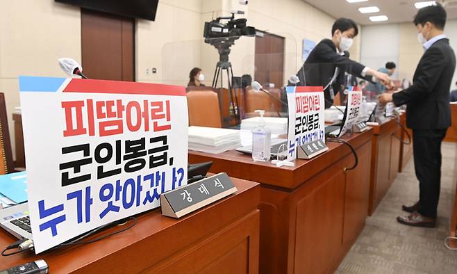 15일 국회에서 열린 국방위원회의 5·18민주화운동 진상규명 조사위, 병무청, 군인공제회 등에 대한 국정감사에서 국민의힘 관계자들이 소속 의원 노트북에 손팻말을 게시하고 있다. 이날 오전 국정감사는 공제회의 대장동 투자 손실을 둘러싼 여야 충돌 탓에 파행했다. 국회사진기자단