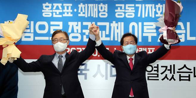국민의힘 대선주자인 홍준표 의원(오른쪽)과 최재형 전 감사원장(왼쪽)이 17일 서울 여의도 홍준표 캠프 사무실에서 열린 최 전 감사원장 영입 행사에서 꽃다발을 들고 포즈를 취하고 있다.  국회사진기자단