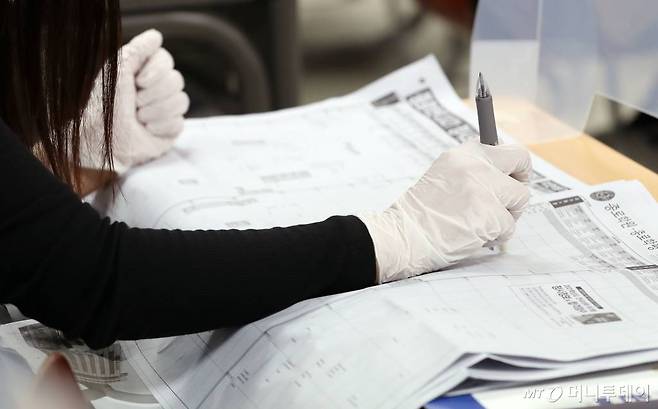 4일 오후 서울 종로학원 강남본원에서 온라인 생중계 방식으로 열린 '수능 직후, 2021 대입전략 설명회'를 찾은 학부모들이 배치참고표를 살펴보고 있다. /사진=김휘선 기자 hwijpg@