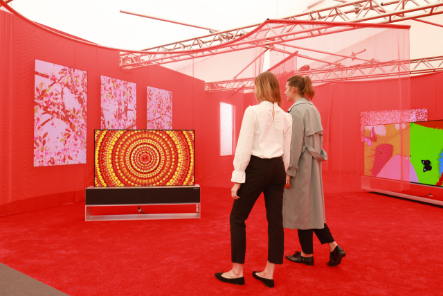 LG전자가 영국 런던 예술전시회 프리즈 아트페어에 오픈한 갤러리를 찾은 관람객들이 롤러블 올레드 TV LG 시그니처 올레드 R로 데미안 허스트의 예술 작품을 감상하고 있다. /사진제공=LG전자