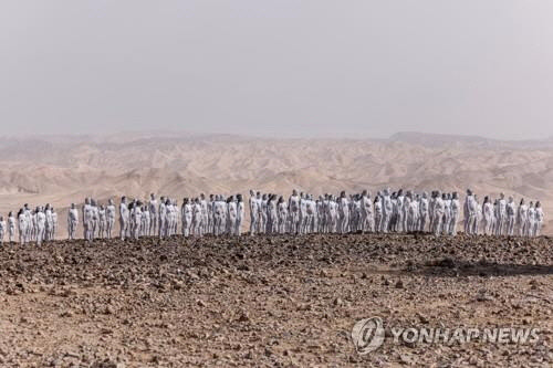 17일(현지시간) 이스라엘 사해 부근 황무지에서 말라가는 사해를 보호하자고 호소하는 취지로 작가 스펜스 투닉을 초청해 누드 사진 촬영이 진행됐다.  [아라드[이스라엘]=로이터 연합뉴스]