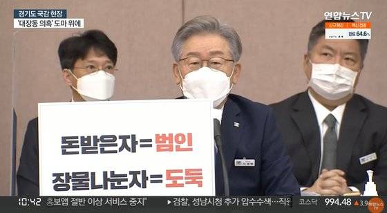 18일 경기도국감 현장에서 이재명 경기도지사가 피켓을 들고 있다. [연합뉴스TV 유튜브 캡처]