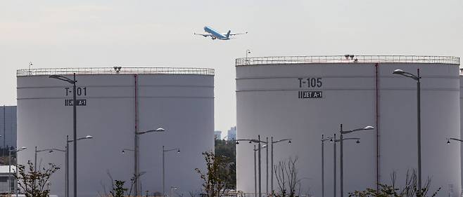 Incheon International Airport’s fuel storage tanks are seen Monday, with a Korean Air plane in the background. (Yonhap)