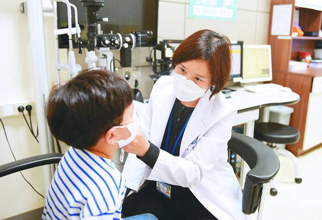 아주대병원 안과 정승아 교수가 눈몰림 증상으로 진료실을 찾은 아이의 사시 여부 검사를 하고 있다. 아주대병원 제공