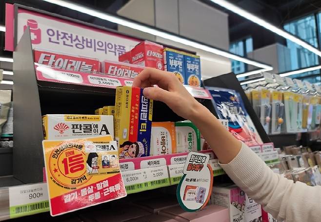 편의점 CU 내 안전상비의약품 코너에서 감기약을 소비자가 고르고 있다 [사진 제공 = CU]