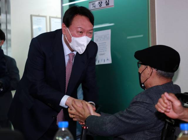 ▲ 국민의힘 윤석열 대선 경선 후보가 18일 오후 부산 동구 부산장애인총연합회를 찾아 관계자와 악수하고 있다. ⓒ연합뉴스