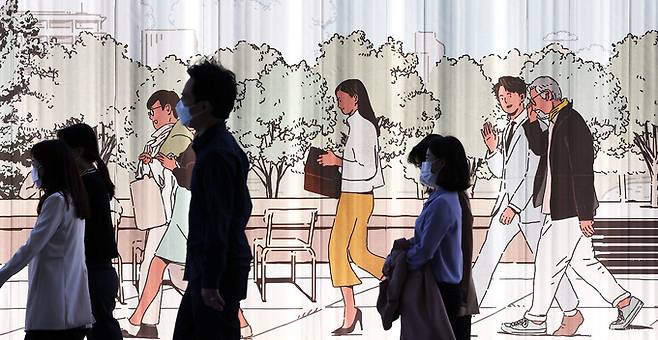 서울 종로구 광화문광장에 일상 생활의 모습이 그려진 공사 담벼락 앞으로 마스크를 착용한 시민들이 걷고 있다. 뉴스1