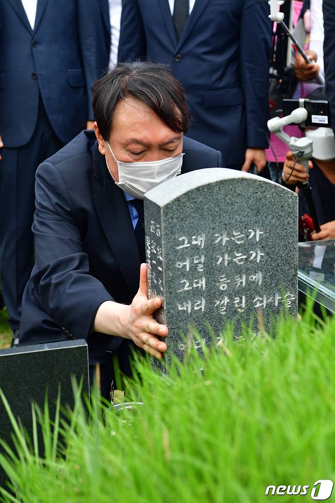 대권 도전에 나선 윤석열 국민의힘 대선경선 후보가 지난 7월 17일 광주 북구 망월동 민족민주열사묘역(5·18 구 묘역)에서 이한열 열사 묘비를 어루만지고 있다. © News1