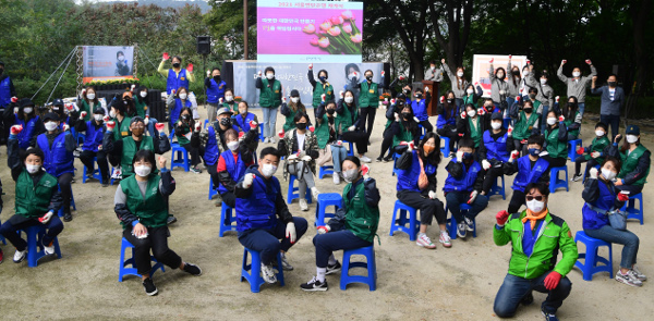 밥상공동체·연탄은행의 연탄 나눔 재개식에 참석한 봉사자들이 지난 16일 서울 서대문구 홍제동 개미마을에서 손을 들고 구호를 외치고 있다. 강민석 선임기자