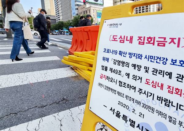 19일 서울 종로구 광화문광장 네거리에 차단막과 함께 도심 내 집회 금지 안내문이 놓여 있다. 민주노총이 20일 서울 도심에서 대규모 집회를 개최하겠다고 신고했지만 정부는 코로나19 확산 방지를 위해 이를 불허하고 자제를 요청했다. [이충우 기자]