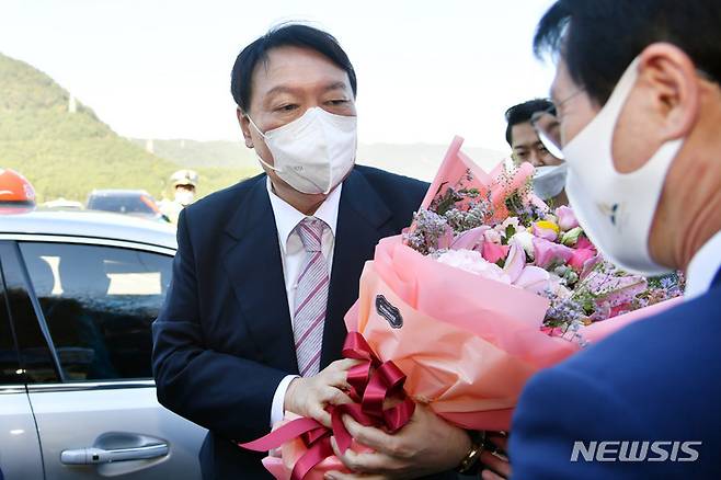 [부산=뉴시스] 하경민 기자 = 윤석열 국민의힘 대통령선거 경선 후보가 19일 부산 연제구 부산개인택시조합에 택시를 타고 온 뒤 꽃다발을 받고 있다. 2021.10.19. yulnetphoto@newsis.com