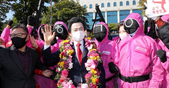 허경영 국가혁명당 명예대표가 18일 오전 과천 중앙선관위에서 제20대 대통령선거 예비후보자 등록을 마치고 ‘오징어 게임’ 복장을 한 지지자들에 둘러싸여 환호에 답하고 있다. 과천=연합뉴스