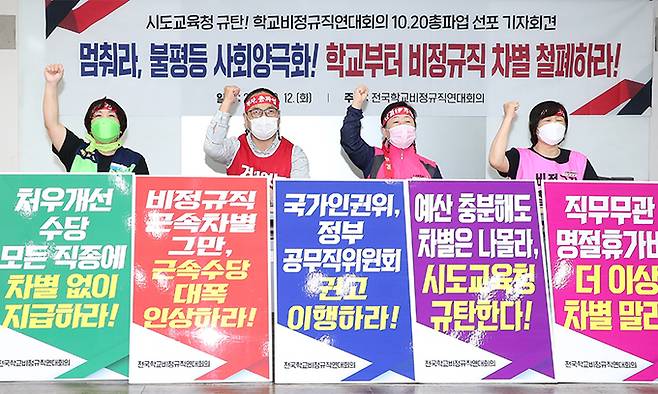 최순임 여성노조 위원장(오른쪽부터), 박미향 학교비정규직노조 위원장, 윤택근 민주노총 위원장 직무대행, 이윤희 교육공무직본부장이 지난 12일 서울 중구 민주노총에서 열린 학교비정규직 파업 찬반투표 결과 발표 및 총파업 총력투쟁 선포 기자회견에서 구호를 외치고 있다. 연합뉴스