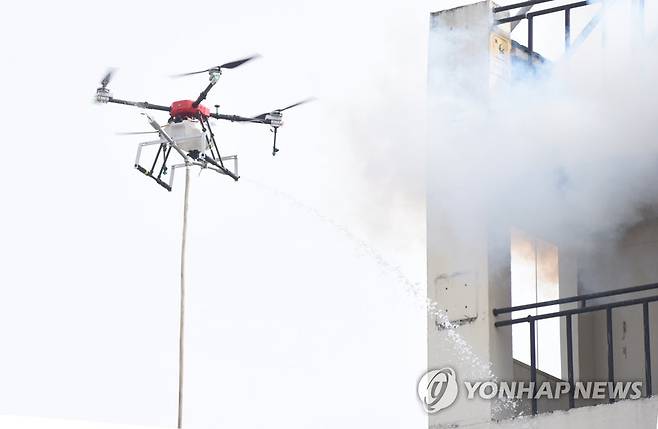 드론 활용한 화재 진압 지난 3월 11일 충남 천안 중앙소방학교 훈련장에서 호스를 매단 화재 진압용 소방드론이 물을 뿌리는 모습 [연합뉴스 자료사진]