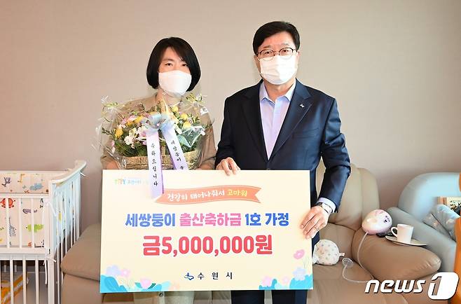 수원시의 '세쌍둥이 이상 출산 축하금' 1호 수혜자 홍은미씨와 염태영 수원시장이 기념촬영을 하고 있다. © 뉴스1