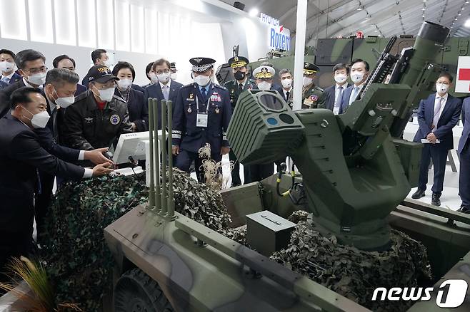 문재인 대통령이 20일 경기도 성남시 서울공항에서 열린 2021 서울 국제 항공우주 및 방위산업 전시회(ADEX)에서 이정엽 현대로템 방산영업실장의 안내를 받으며 현대로템 전시장을 관람하고 있다.2021.10.20/뉴스1 © News1 이광호 기자