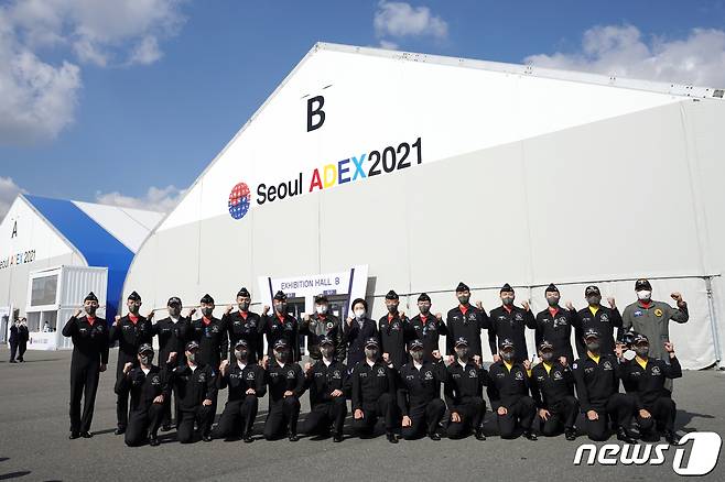 문재인 대통령과 김정숙 여사가 20일 경기도 성남시 서울공항에서 열린 2021 서울 국제 항공우주 및 방위산업 전시회(ADEX) 개막 기념행사에 참석해 시범비행을 마친 공군 특수비행팀 블랙이글스 대원들과 기념촬영을 하고 있다. 2021.10.20/뉴스1 © News1 이광호 기자