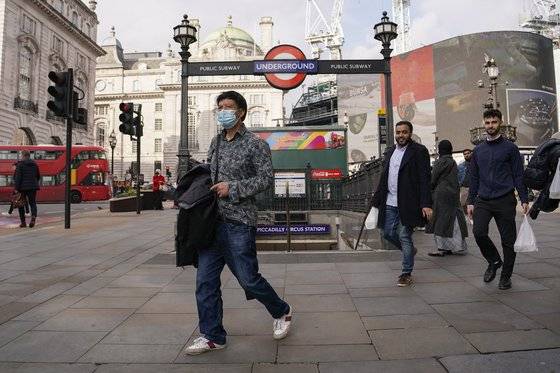 19일(현지시간) 한 영국인이 마스크를 쓰고 런던시 피카딜리 광장을 지나가고 있다. [AP=연합뉴스]
