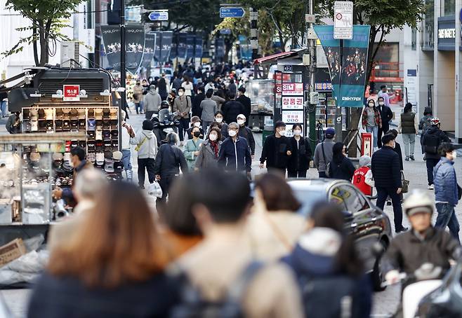 Masked citizens roam the streets of Myeong-dong, a popular tourist district in central Seoul, on Sunday. (Yonhap)