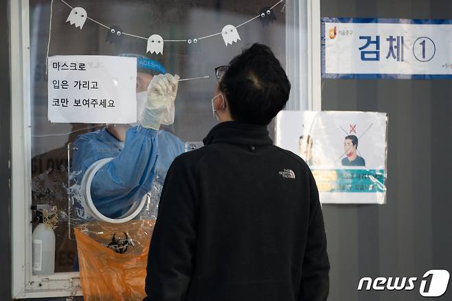 (서울=뉴스1) 유승관 기자 = 20일 서울역광장에 마련된 신종 코로나바이러스 감염증(코로나19) 중구 임시선별검사소를 찾은 시민들이 검체 검사를 받고 있다.  질병관리청 중앙방역대책본부는 20일 0시 기준 코로나19 신규 확진자가 1571명 발생했다고 밝혔다. 이는 어제보다 498명 증가한 수치다. 2021.10.20/뉴스1