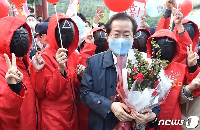 (대구=뉴스1) 공정식 기자 = 국민의힘 대선 경선 후보인 홍준표 의원이 20일 오후 대구 수성구 대구MBC에서 열리는 대구·경북 합동토론회에 참석하며 응원 나온 오징어게임 진행요원 복장의 지지자들과 기념사진을 찍고 있다. 2021.10.20/뉴스1